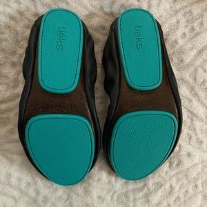 Black leather Tieks. Never worn. Packable bag and mini carry bag included.